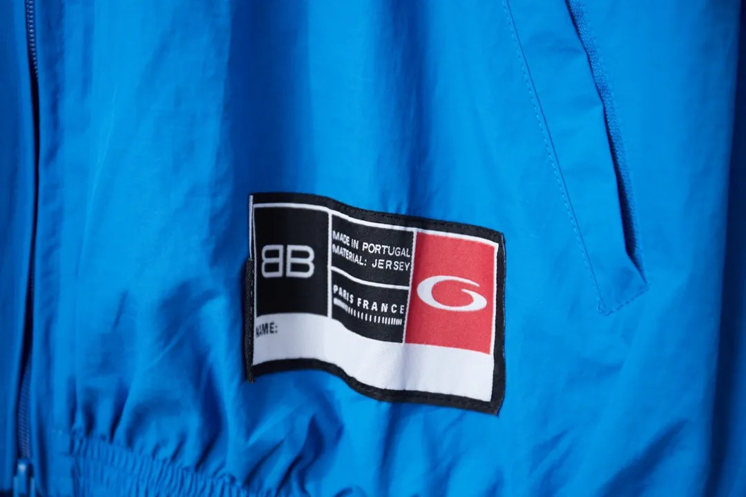 Balenciaga 𝘽𝘼𝙇𝙀𝙉𝘾𝙄𝘼𝙂𝘼 BLCG 26SS 77 Half Ring 01 Embroidered Basketball Jacket Light luxury essential item for daily commuting for men and women Correct version Welcome to compare Detailed features · Customized matt Taslan jacket fabric · The entire fabric is pre-treated with a waterproof coating · The interior is made of three-grade polyester bird's eye mesh · OS ultra-loose silhouette design · Side zipper pockets Small stand-up collar design · Internal zipper pocket design · Elastic waistband design at the hem · Customized molded hardware zipper Jacket double puller design · Laser engraved patch burning process · Imported environmentally friendly glue thermoset ink printing process · Original main mark washable tag brand packaging Color: White/Blue Size: 46/48/50/52
